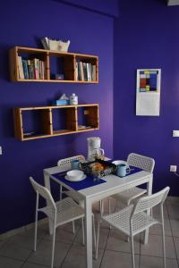 einem Esstisch mit Stühlen und einer lila Wand in der Unterkunft Sophie's choice in Nafplio