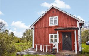 une grange rouge avec une table et une porte dans l'établissement 2 Bedroom Amazing Home In deshg, à Ödeshög