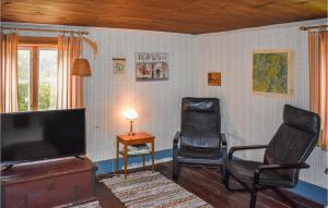 - un salon avec deux chaises et une télévision à écran plat dans l'établissement 2 Bedroom Amazing Home In deshg, à Ödeshög