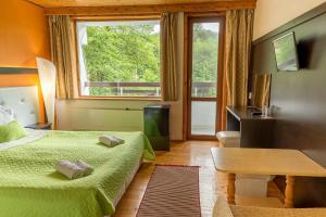 a bedroom with two beds and a table and a window at Райски кът in Kalofer