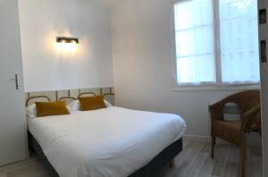 ein Schlafzimmer mit einem weißen Bett und einem Fenster in der Unterkunft Artimon Beach appart Les Sables d Olonne in Les Sables-dʼOlonne