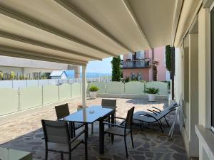 a patio with a table and chairs on a balcony at Apartments Peninsula in Sirmione
