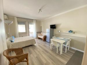 ein kleines Zimmer mit einem Bett, einem Tisch und Stühlen in der Unterkunft Apartments Peninsula in Sirmione