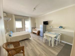 a small room with a bed and a table and chairs at Apartments Peninsula in Sirmione