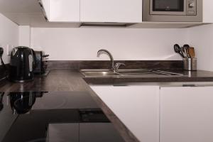 a kitchen with a sink and a microwave at GreenStar Apartments in Dundee