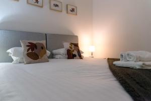 1 dormitorio con 1 cama con sábanas y almohadas blancas en GreenStar Apartments en Dundee