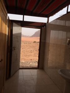 Baño con vistas al desierto a través de una puerta en Bedouin House Camp, en Wadi Rum