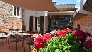 eine Terrasse mit roten Blumen, Tischen und Stühlen in der Unterkunft L'Iris B&B in Terrazza in Lucca