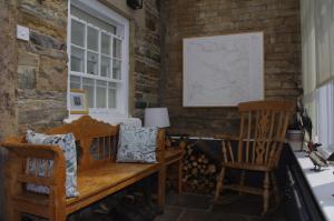 a room with a wooden bench and two chairs at Brunswick House in Middleton in Teesdale