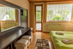 a bedroom with two beds and a desk and windows at Hotel Paradise Place in Kalofer