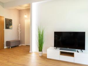 ウニエシチェにあるVacationClub – Enklawa Apartament 11のリビングルーム(白いキャビネット、薄型テレビ付)