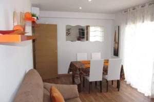 a dining room with a table and white chairs at piso con estilo cerca de la playa in Cullera
