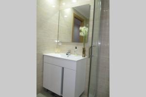 a white bathroom with a sink and a shower at piso con estilo cerca de la playa in Cullera