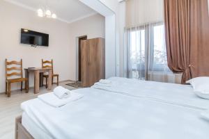 a hotel room with two beds and a window at White Hotel Guesthouse in Zugdidi