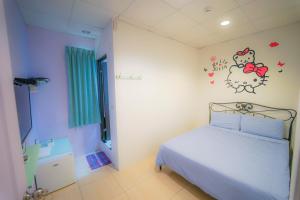 um quarto com uma cama com um adesivo de Hello Kitty na parede em Chen Je B&B em Xiaoliuqiu