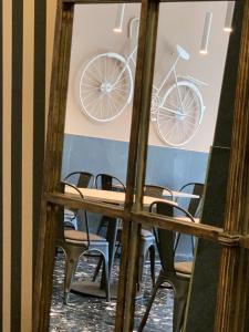 stół i krzesła z rowerem na ścianie w obiekcie Hotel Ariston w Mestre