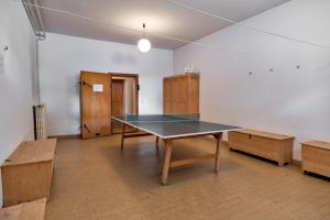 un tavolo da ping pong in una stanza con mobili in legno di Chesa Spuondas - Celerina a Celerina