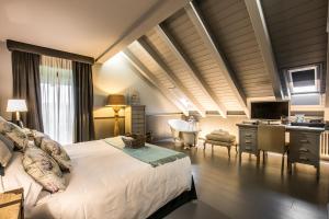 a bedroom with a bed and a desk with a computer at Meltar Boutique Hotel Golf & SPA in Asiago