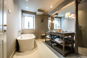 a bathroom with a tub and a toilet and a sink at Meltar Boutique Hotel Golf & SPA in Asiago