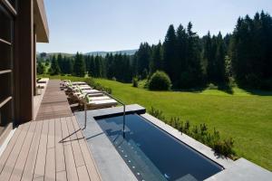 a backyard with a swimming pool and a house at Meltar Boutique Hotel Golf & SPA in Asiago