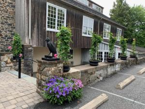 una estatua de pájaro frente a un edificio con flores en The Inn at Montchanin Village & Spa en Montchanin