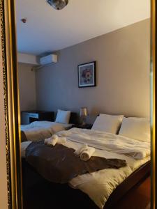 a mirror reflection of a bedroom with two beds at Hotel Prestige Struga in Struga