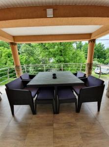 a table and chairs on a patio with a roof at SergillioHouse in Chişcău