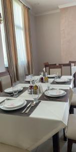 a table with white plates and silverware on it at Hotel Prestige Struga in Struga