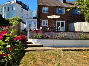 a house with a flower garden in front of it at Luxury Suntrap in Private Complex St Leonards in Hastings