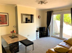 a living room with a table and a couch at Luxury Suntrap in Private Complex St Leonards in Hastings