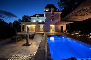 une maison avec une piscine en face d'une maison dans l'établissement LA VILLA AUBIN belle demeure avec vue sur Paris, à Montmorency