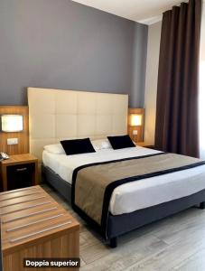 Un pat sau paturi într-o cameră la Hotel Ariston