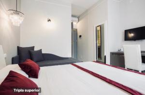 a bedroom with a large white bed with red pillows at Hotel Ariston in Mestre