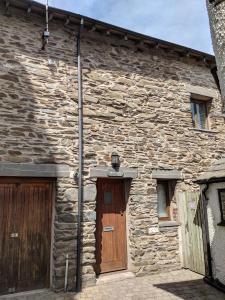 un edificio de piedra con 2 puertas y una puerta de madera en Moss Tarn, en Ulverston