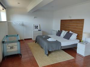 a bedroom with a large bed with a wooden headboard at Paraíso Hills - Encostas do Paraíso: tranquilidade no Douro in Resende