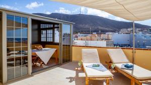 a balcony with chairs and a table on a roof at Maxorata in Morro del Jable