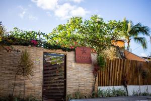 a building with a gate and a fence with flowers at Pousada Casamar in Porto De Galinhas