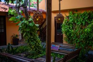 un banco frente a una casa con plantas en Pousada Casamar, en Porto de Galinhas