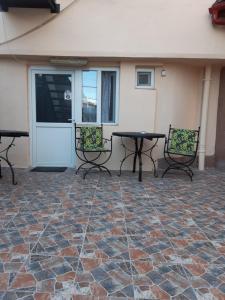 a patio with chairs and a table and a door at Villa Sun & Sea in Constanţa