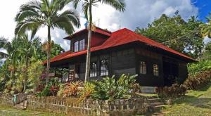 een huis met een rood dak en palmbomen bij Argovia Finca Resort in Tapachula