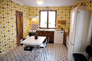a kitchen with a table and chairs and a refrigerator at Gîte Version 70 in Mondrepuis