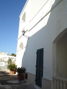 ein weißes Gebäude mit einem Fenster und einer Tür in der Unterkunft Appartamento Leuca in Santa Maria di Leuca