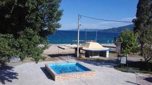 a small swimming pool in front of the ocean at Poseidon rooms in Nea Vrasna