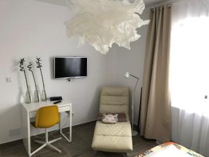 a room with a desk and a chair and a tv at Sunset apartment in Bistriţa