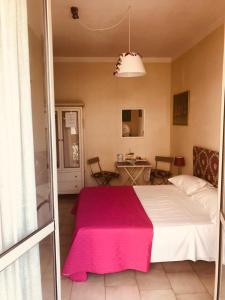 a bedroom with a large bed with a pink blanket at All My Home in Villa San Giovanni