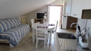 ein Wohnzimmer mit Sofa und Tisch in der Unterkunft Appartamento panoramico Santa Domenica in Santa Domenica