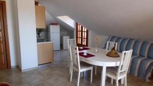 eine Küche und ein Esszimmer mit einem weißen Tisch und Stühlen in der Unterkunft Appartamento panoramico Santa Domenica in Santa Domenica