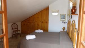 ein Schlafzimmer mit einem großen Bett und einem Stuhl in der Unterkunft Appartamento panoramico Santa Domenica in Santa Domenica