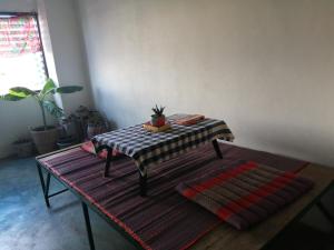 einen Tisch in einem Raum mit einem Tisch und einer Pflanze darauf in der Unterkunft Chill Pill Hostel in Chiang Khan
