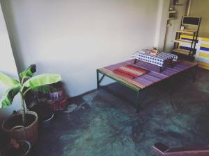 a living room with a table and a plant at Chill Pill Hostel in Chiang Khan